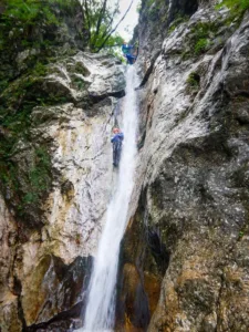 Canyoning through waterfall in Soča valley in Slovenia